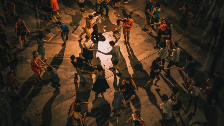 Top-down view of people dancing in a public square.
